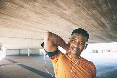 Buy stock photo Shot of a young man experiencing neck pain while working out against an urban background