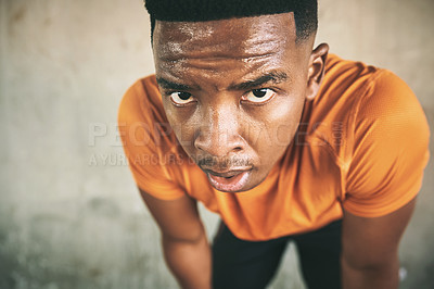 Buy stock photo Shot of a young man taking a break after working out against an urban background