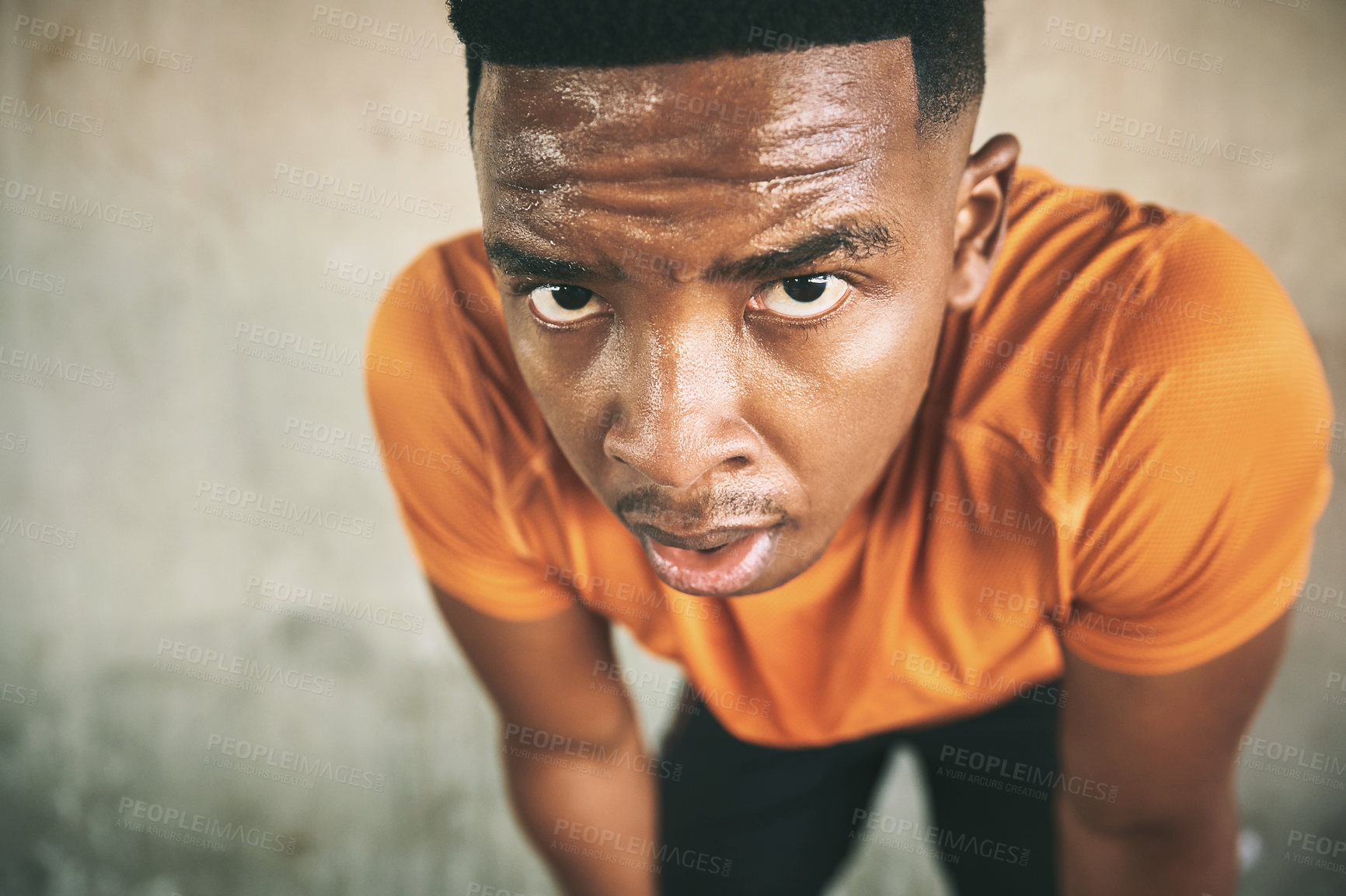 Buy stock photo Shot of a young man taking a break after working out against an urban background