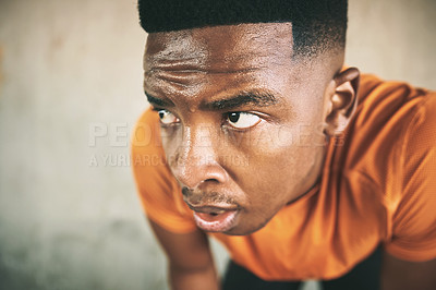 Buy stock photo Shot of a young man taking a break after working out against an urban background
