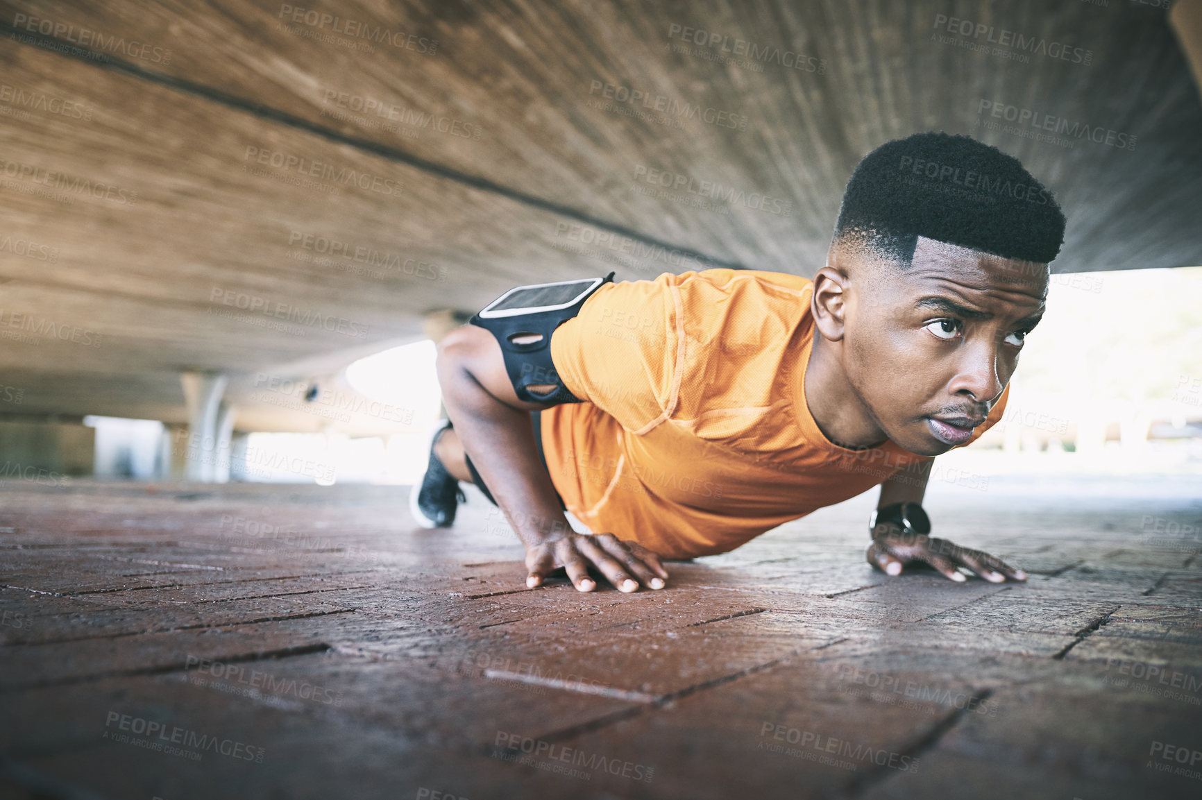 Buy stock photo Shot of a young man doing pushups against an urban background