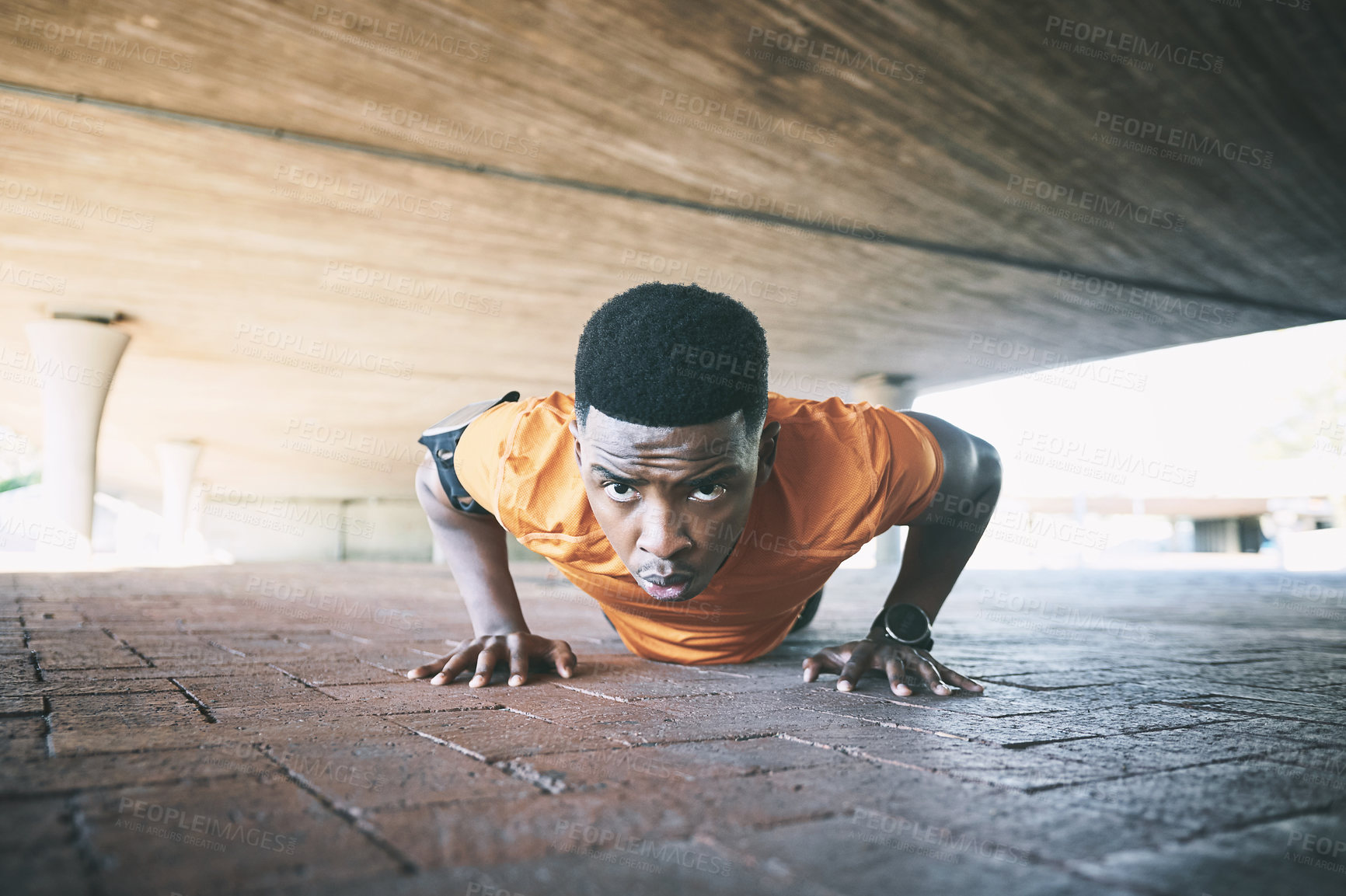 Buy stock photo Shot of a young man doing pushups against an urban background