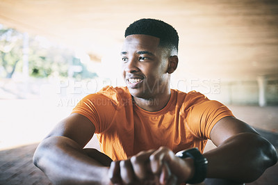 Buy stock photo Shot of a young man taking a break after working out against an urban background