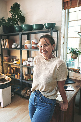 Buy stock photo Cropped portrait of an attractive young business owner standing alone in her pottery studio during the day