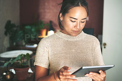 Buy stock photo Cropped shot of an attractive young business owner standing alone in her pottery studio and using a tablet