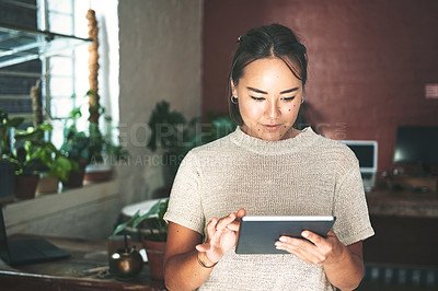 Buy stock photo Cropped shot of an attractive young business owner standing alone in her pottery studio and using a tablet