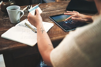 Buy stock photo Cropped shot of an unrecognizable business owner sitting alone in her studio and using a tablet for online shopping