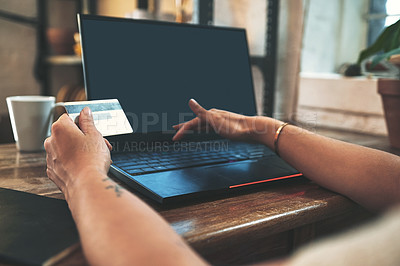 Buy stock photo Cropped shot of an unrecognizable business owner sitting alone in her studio and using a laptop for online shopping