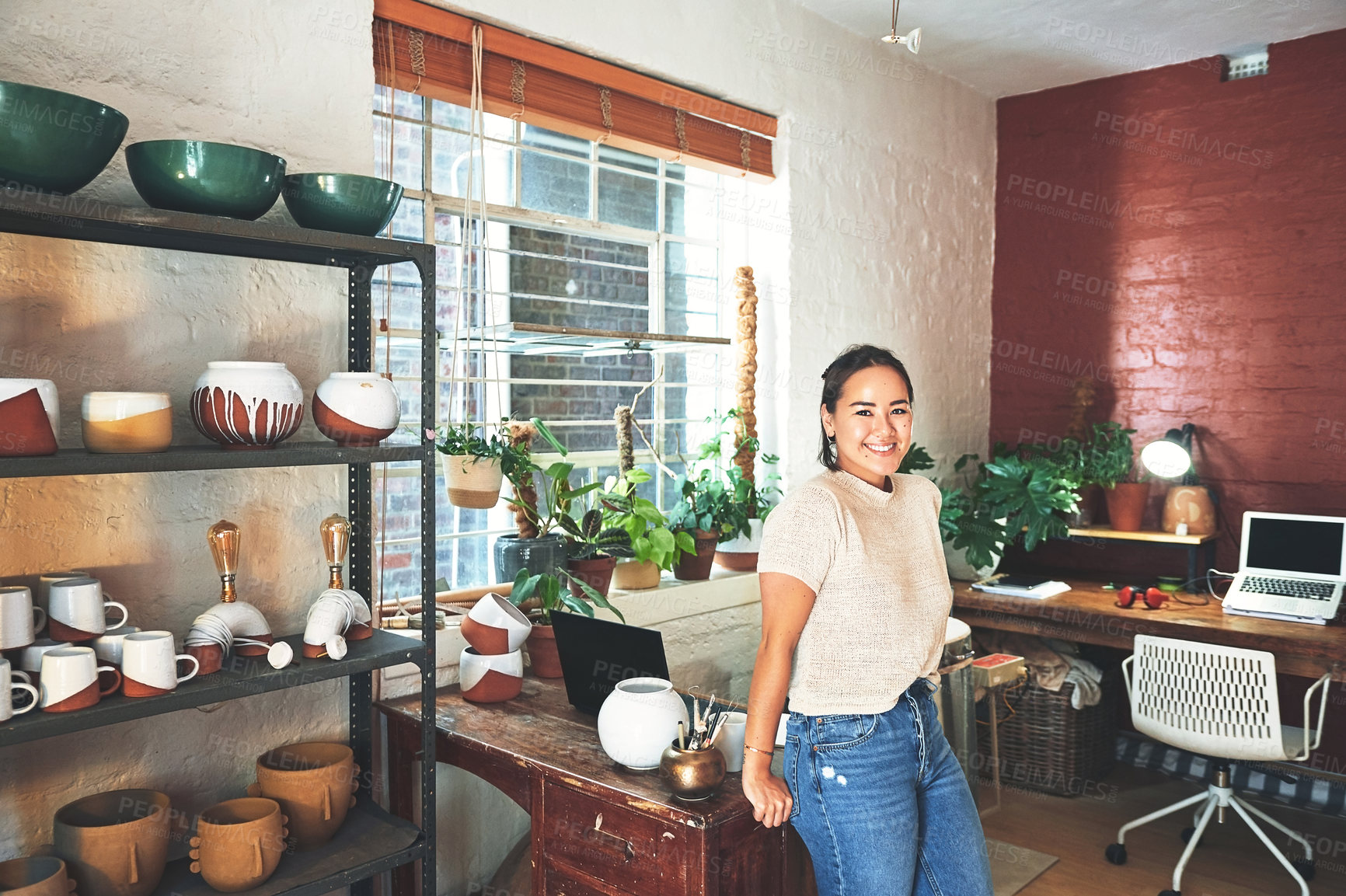 Buy stock photo Cropped portrait of an attractive young business owner standing alone in her pottery studio during the day