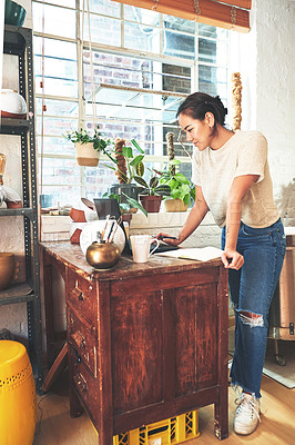 Buy stock photo Full length shot of an attractive young business owner standing alone in her pottery studio and using her laptop