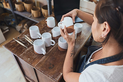 Buy stock photo Shot of a young woman making mugs in a pottery studio