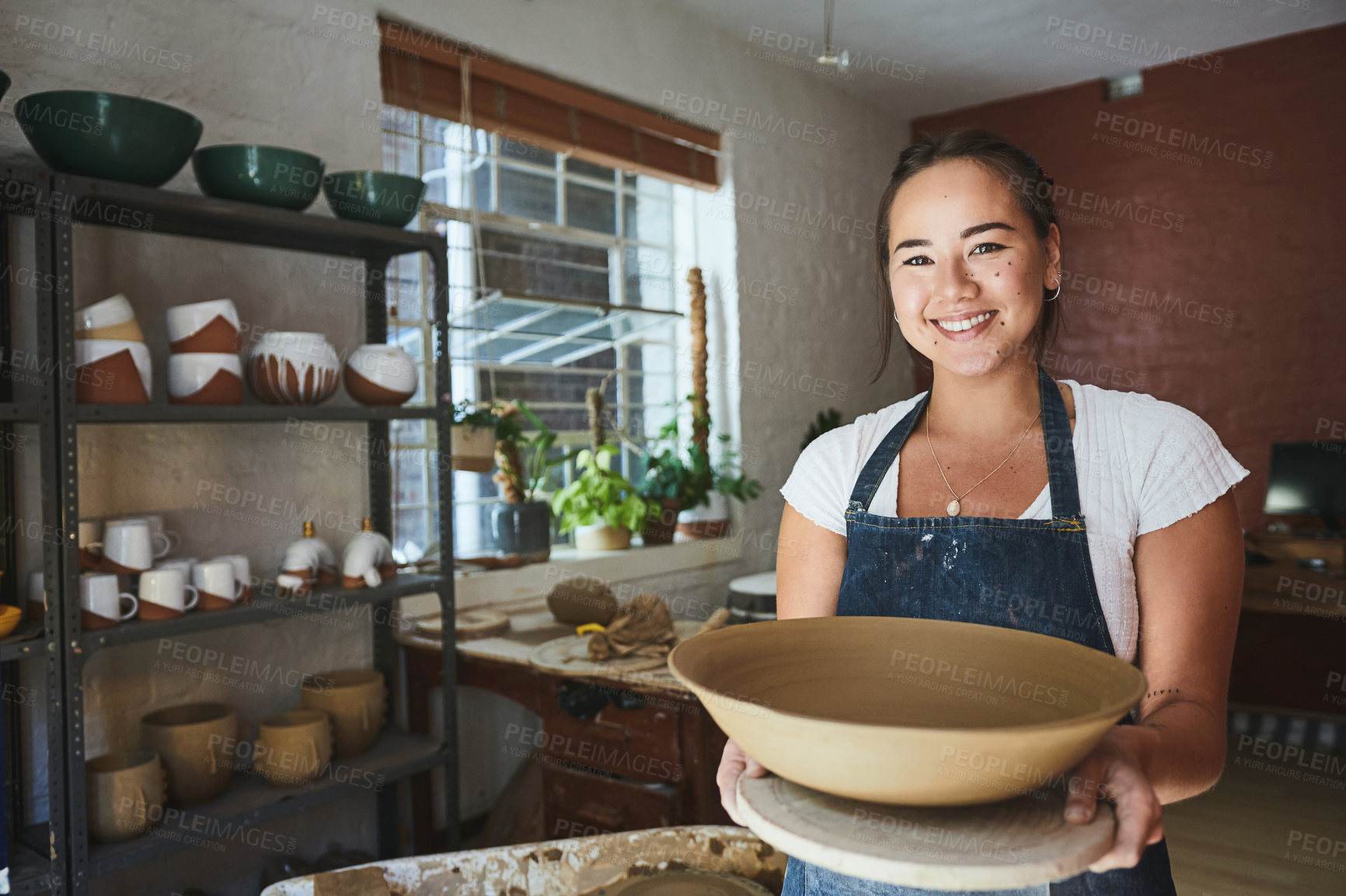 Buy stock photo Shot of a young woman making a bowl in a pottery studio