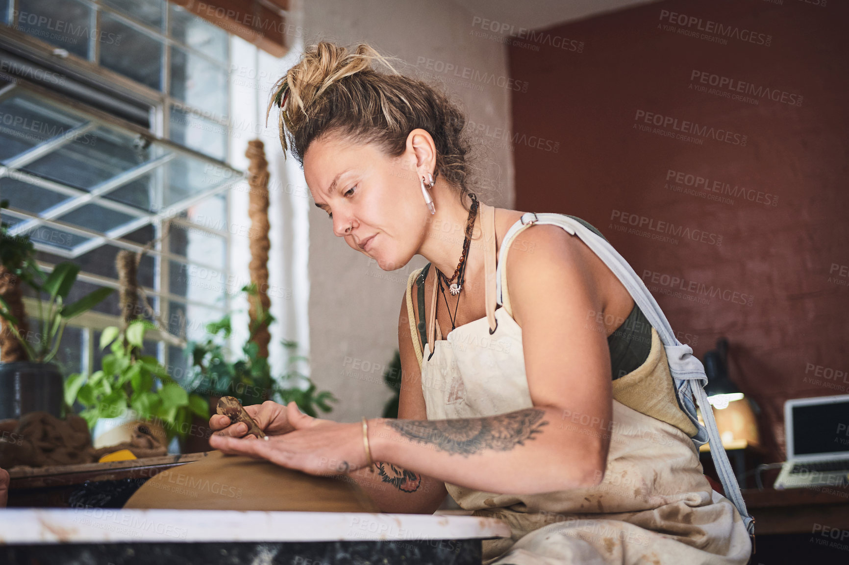 Buy stock photo Shot of a young woman working with clay in a pottery studio