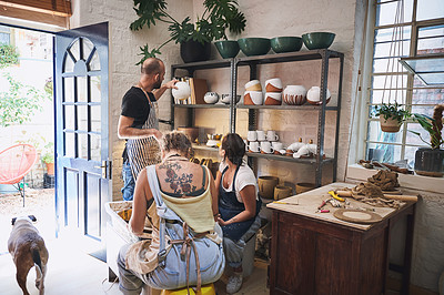 Buy stock photo Shot of a group of young people working with clay in a pottery studio