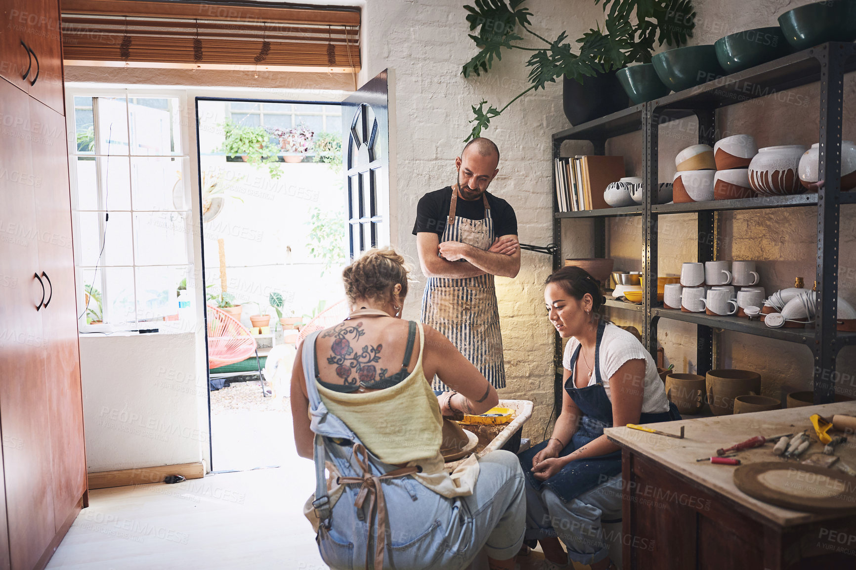 Buy stock photo Shot of a group of young people working with clay in a pottery studio