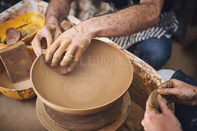 Buy stock photo Shot of an unrecognisable man and woman working with clay in a pottery studio