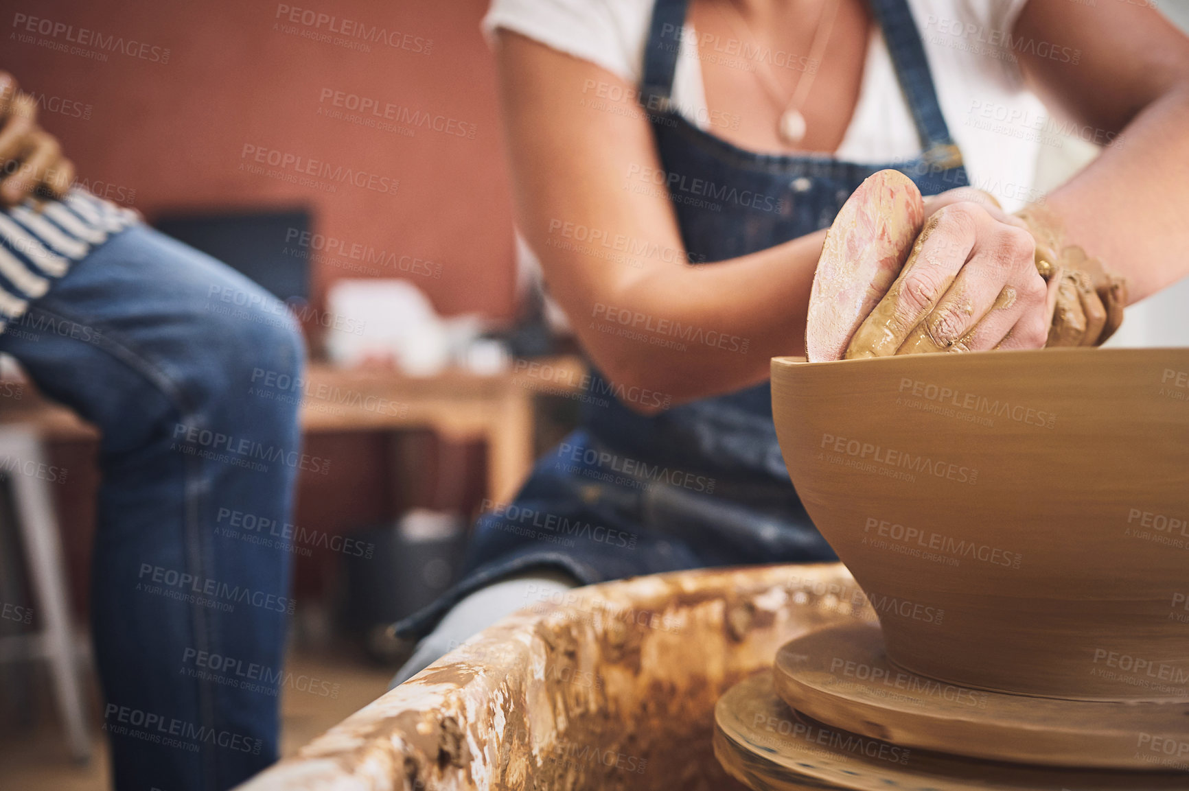 Buy stock photo Shot of an unrecognisable woman working with clay in a pottery studio