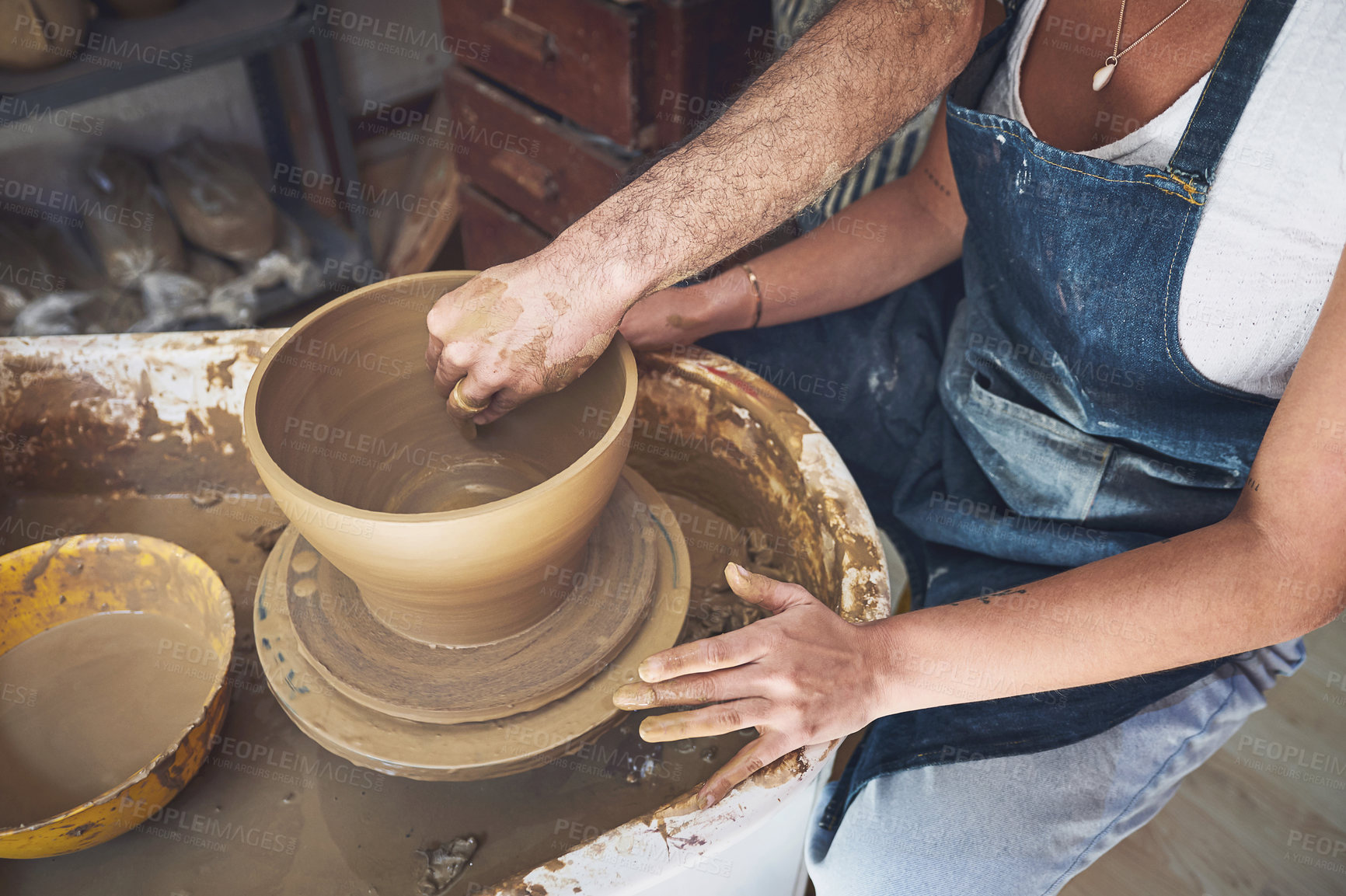 Buy stock photo Shot of an unrecognisable man and woman working with clay in a pottery studio