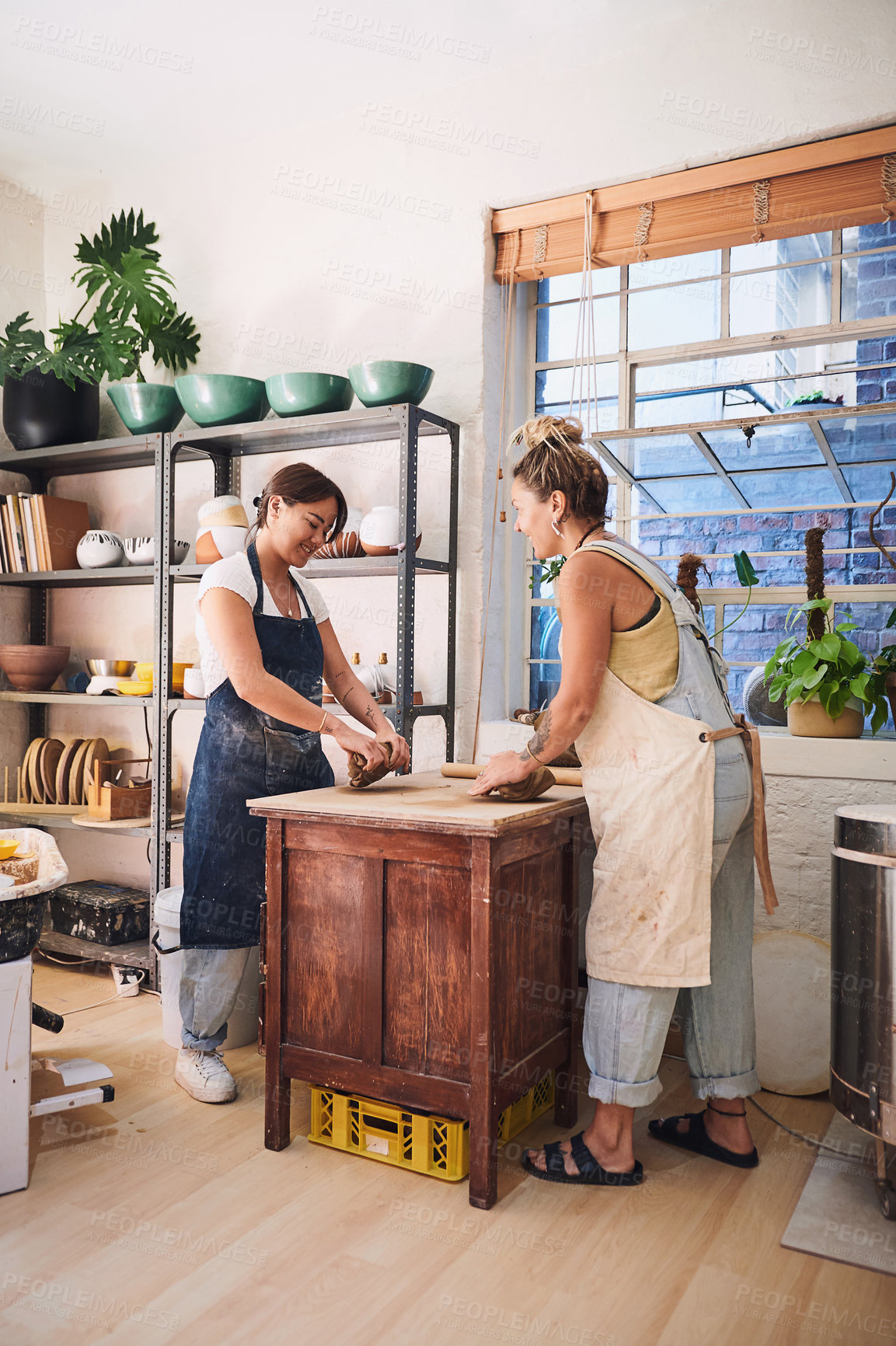 Buy stock photo Women, learning and clay in studio for pottery, guide and development for new skill with teacher. People, mentor and talking with mold, happy and design with art, sculpture and creativity in workshop