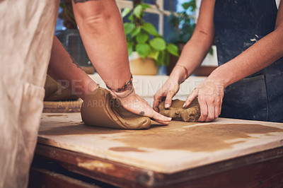 Buy stock photo Shot of two unrecognisable women kneading clay in a pottery studio