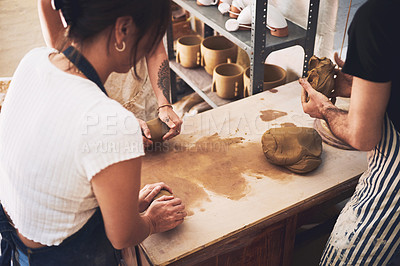 Buy stock photo Shot of a young woman kneading clay in a pottery studio