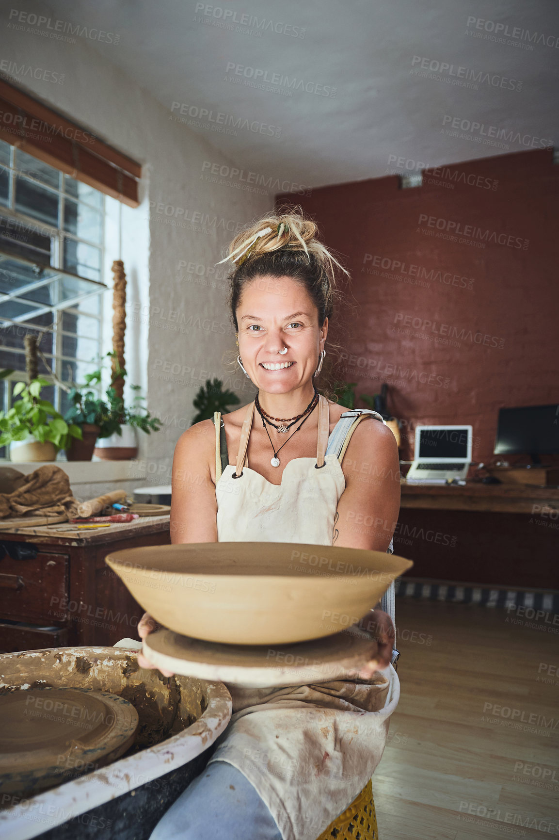 Buy stock photo Shot of a young woman making a bowl in a pottery studio