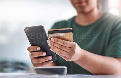 Buy stock photo Shot of an unrecognisable woman using a smartphone and credit card at her desk