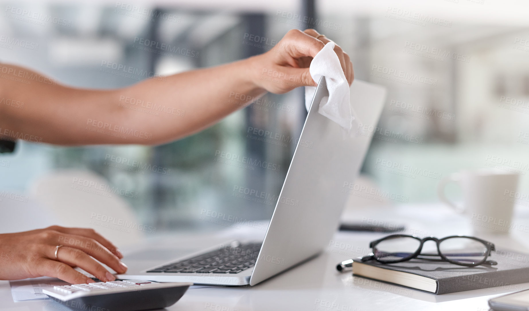 Buy stock photo Closeup shot of an unrecognisable businesswoman cleaning a laptop in an office