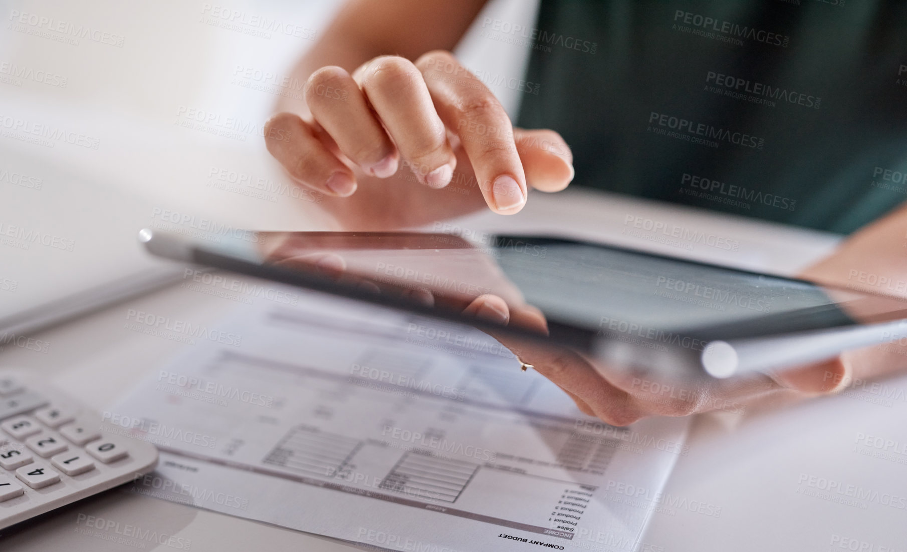 Buy stock photo Closeup shot of an unrecognisable businesswoman using a digital tablet while going through paperwork in an office