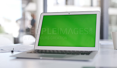 Buy stock photo Shot of a laptop with a green screen on a desk in a modern office