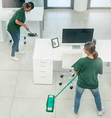 Buy stock photo High angle shot of two young woman cleaning a modern office