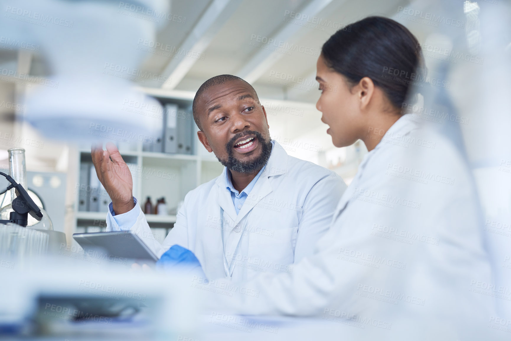 Buy stock photo Shot of two scientists having a discussion in a lab