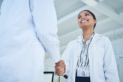 Buy stock photo Shot of two scientists shaking hands in a lab