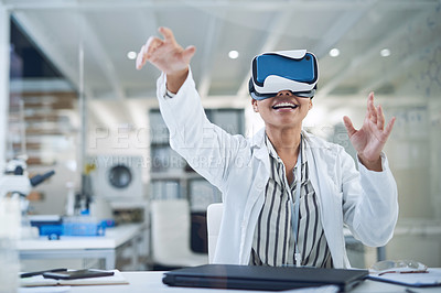 Buy stock photo Shot of a young scientist using a virtual reality headset while working in a lab