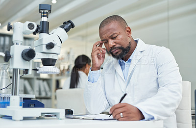 Buy stock photo Shot of a mature scientist going through paperwork in a lab