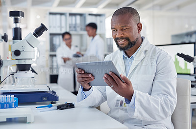 Buy stock photo Shot of a mature scientist using a digital tablet in a lab