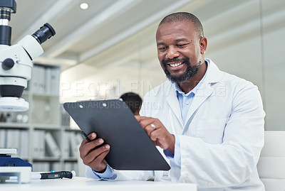 Buy stock photo Shot of a mature scientist going through paperwork in a lab