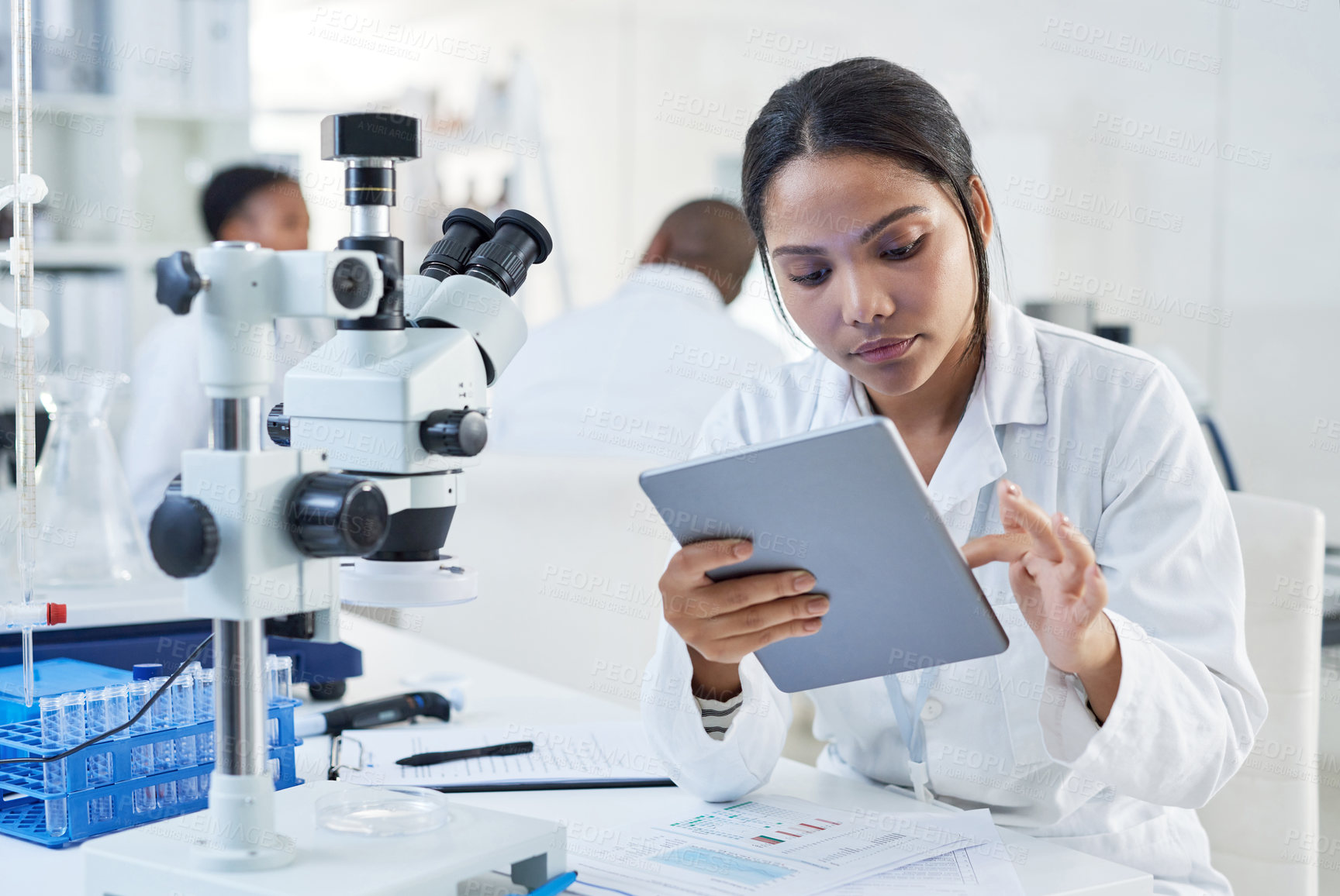 Buy stock photo Shot of a young scientist using a digital tablet in a lab