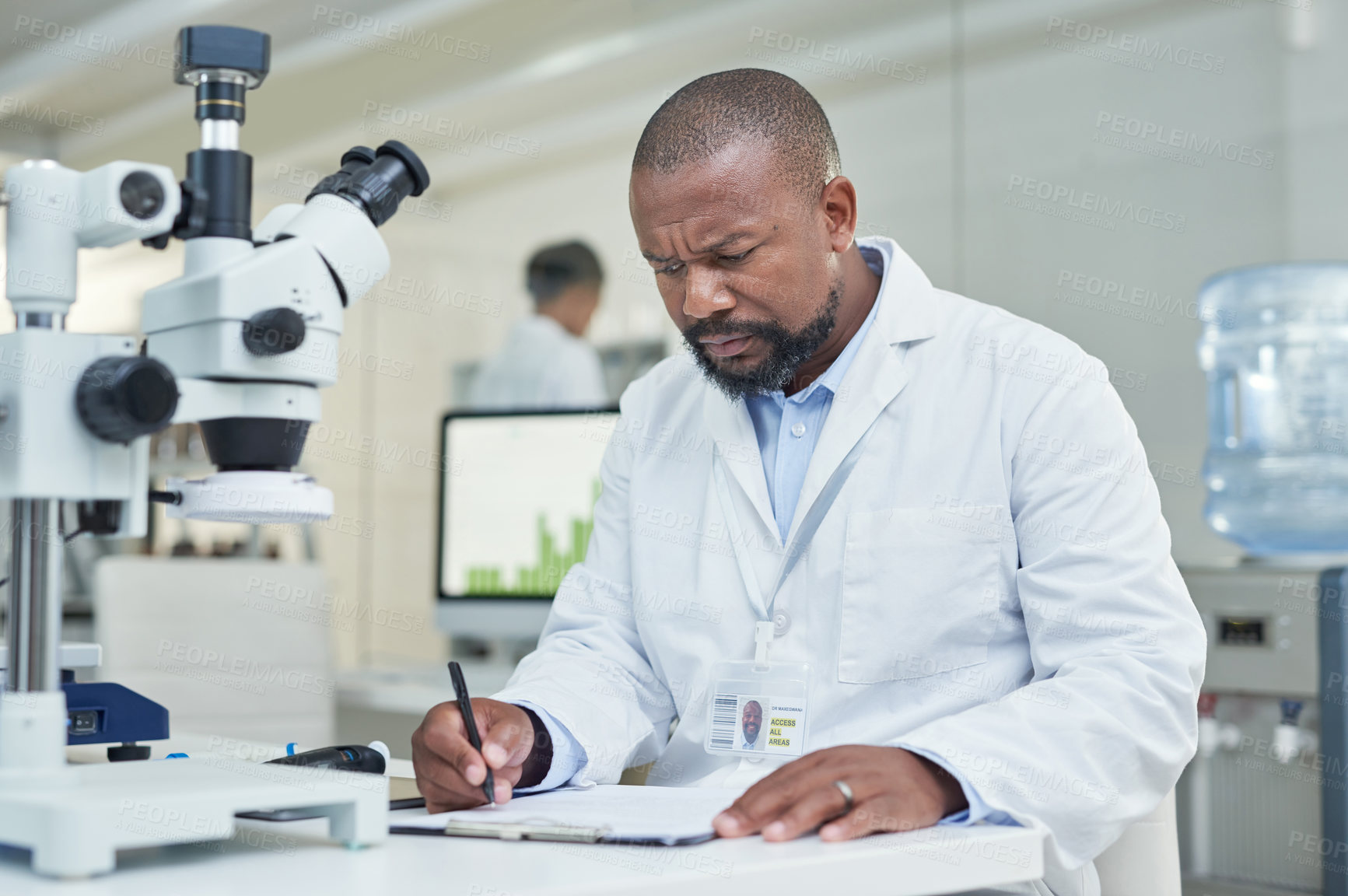 Buy stock photo Shot of a mature scientist going through paperwork in a lab