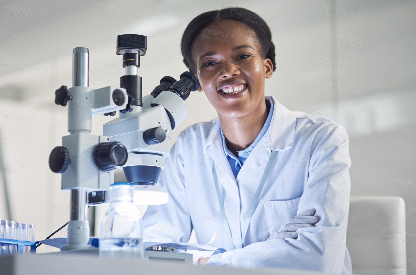 Buy stock photo Portrait of a young scientist using a microscope in a lab