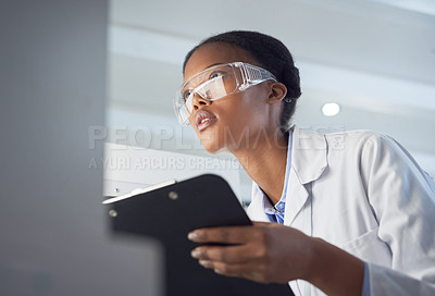 Buy stock photo Shot of a young scientist using a computer while conducting research in a laboratory