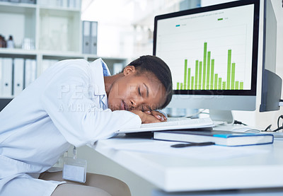 Buy stock photo Shot of a young scientist sleeping at her desk while conducting research in a laboratory