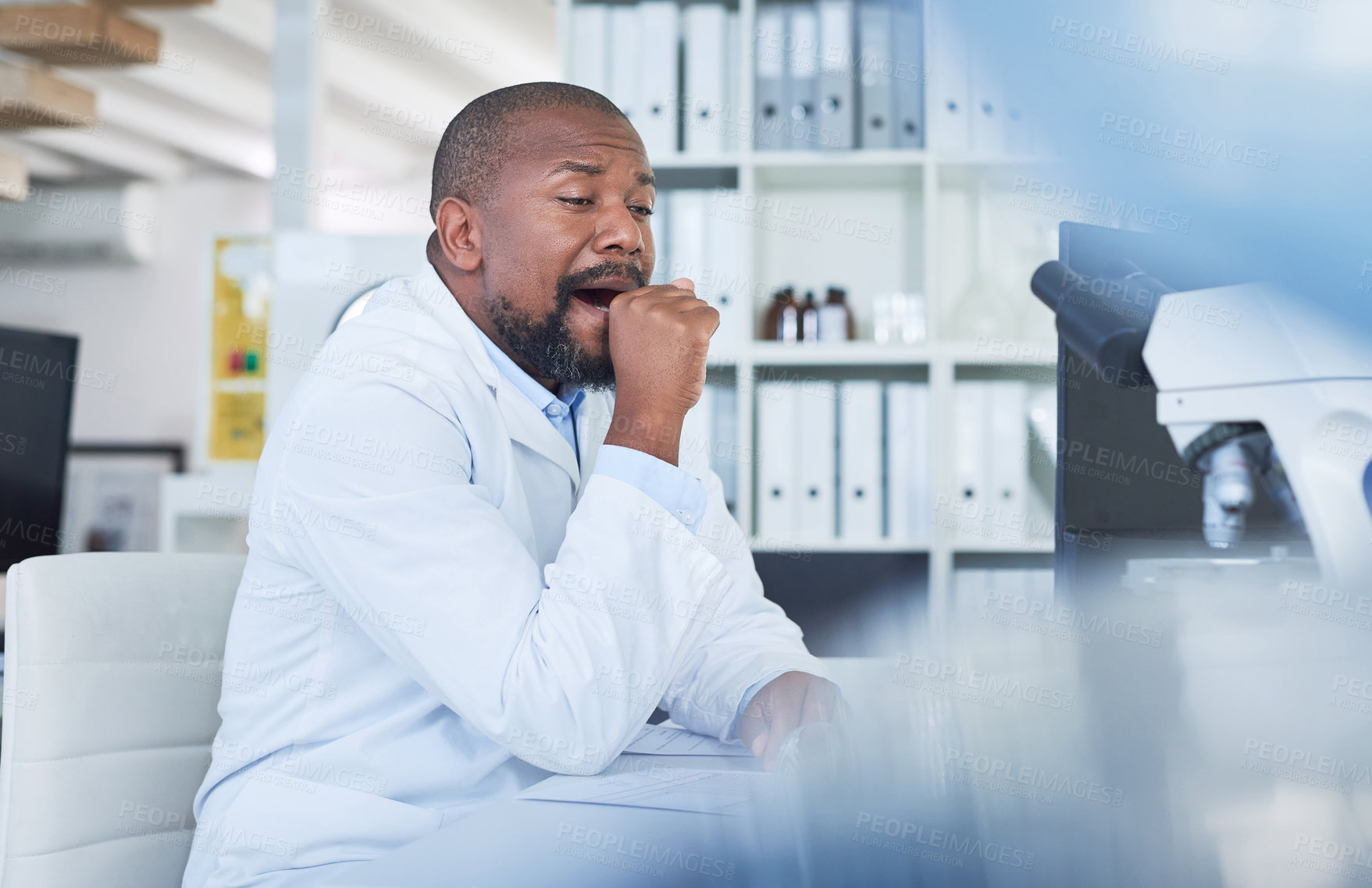 Buy stock photo Shot of a scientist looking tired while conducting research in a laboratory