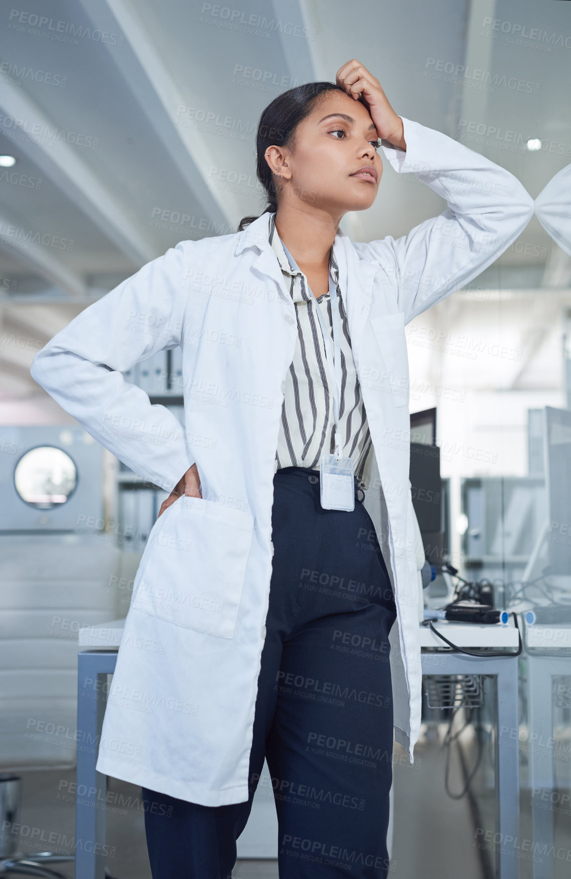 Buy stock photo Shot of a young scientist looking stressed while conducting research in a laboratory