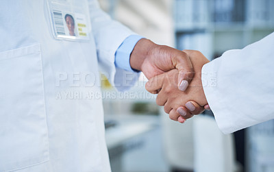 Buy stock photo Shot of two unrecognisable scientists shaking hands in a laboratory