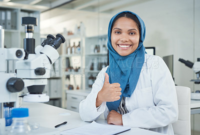 Buy stock photo Portrait of a young scientist showing thumbs up while conducting research in a laboratory