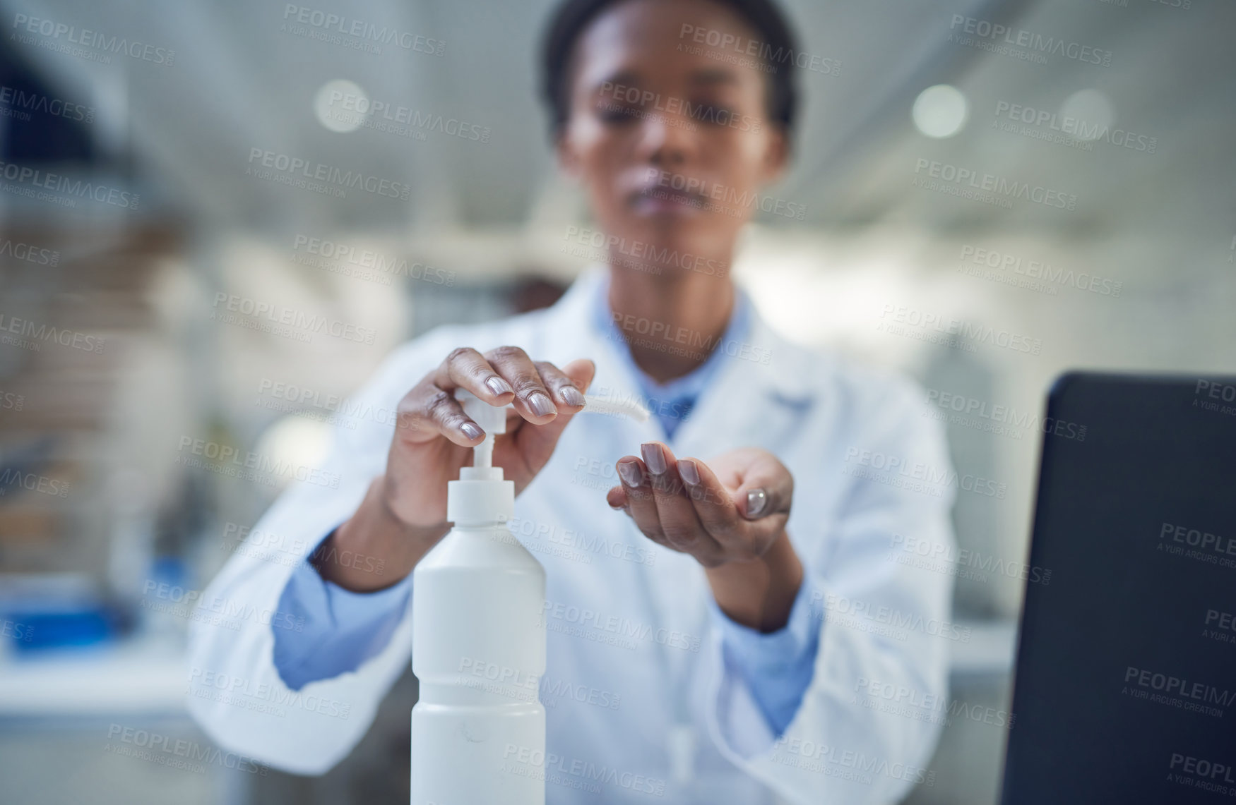 Buy stock photo Shot of a scientist disinfecting her hands while conducting research in a laboratory