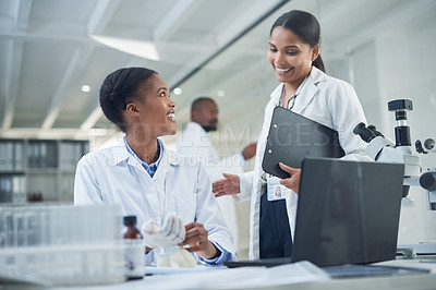 Buy stock photo Shot of two young scientists having a discussion in a laboratory