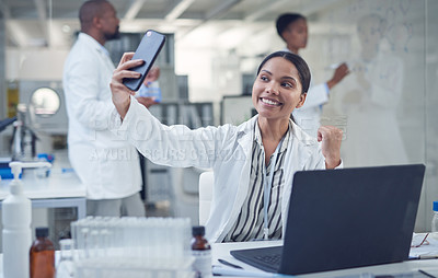 Buy stock photo Shot of a young scientist taking a selfie while conducting research in a laboratory