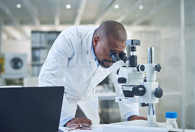 Buy stock photo Shot of a scientist using a microscope while conducting research in a laboratory